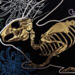 A golden bunny skeleton rests inside a burrow of chrysanthemums