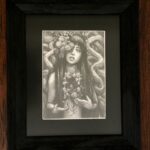 Graphite drawing of a female representing figure with marigolds coming out of one of her eyes. Long dark hair. Chest open, edges look like bark. A marigold comes out of the space. Tree branches at her back.