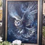 Night Messenger, a framed mystical owl painting displayed beside flowers.