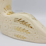 A closeup of the gold floral details on the wings